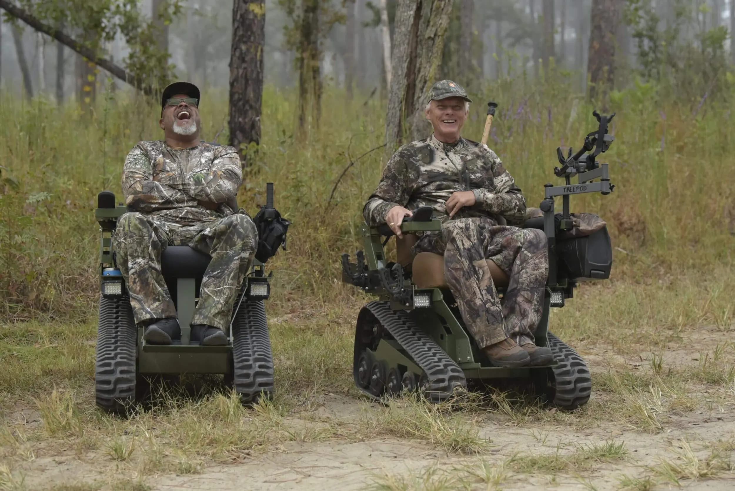 Two riders in camouflage seated in EcoRovers during a mobility-impaired hunt outing.