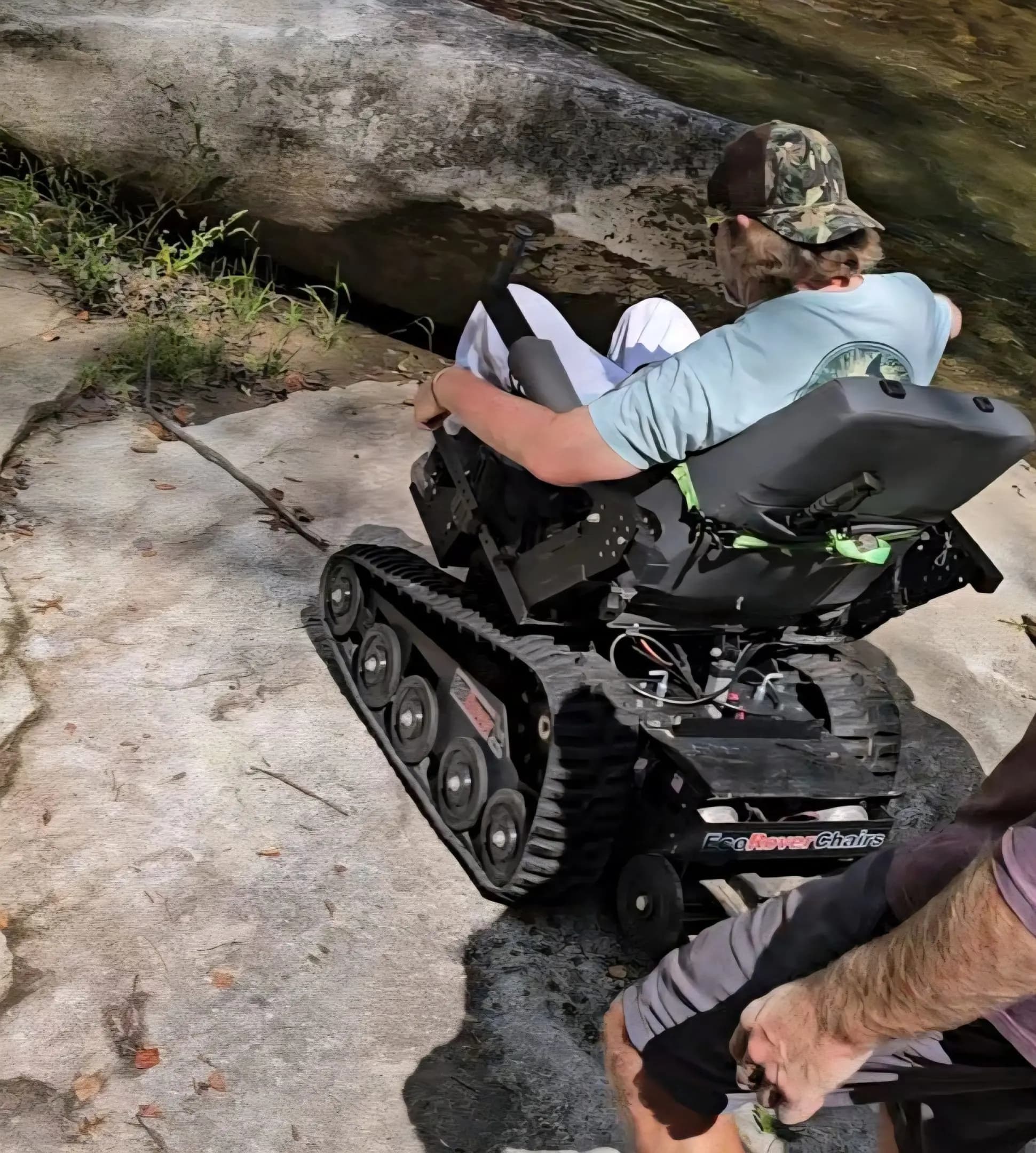 An EcoRover navigating down rocky terrain beside a creek, showing the rubber track system in action.